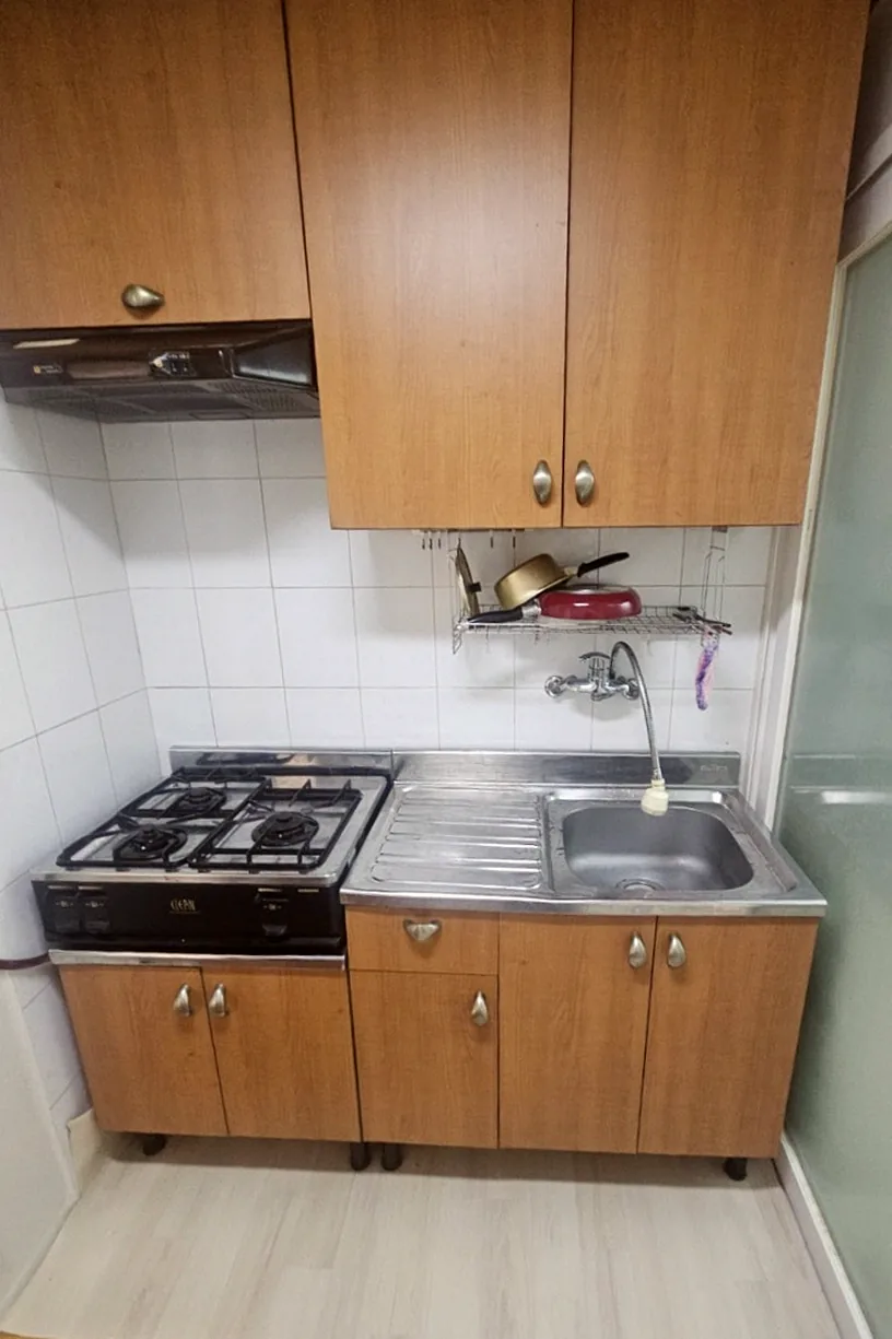 정리를 마친 주방 — 나무색 수납장과 깨끗한 싱크대