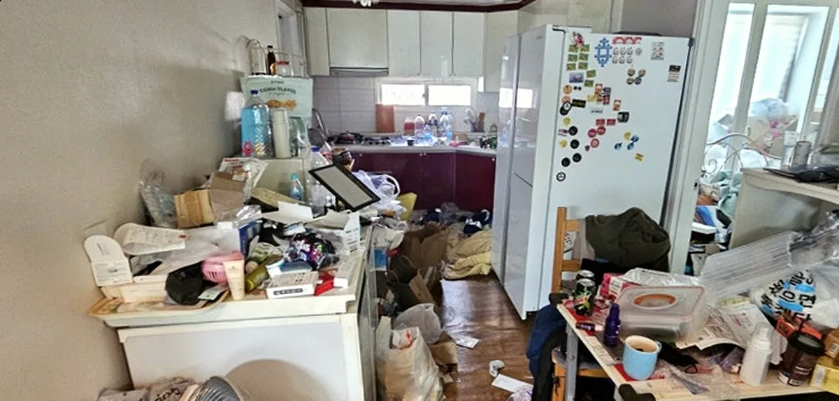 정리 전 주방 — 자석이 빼곡한 냉장고와 반찬통·약봉지가 놓인 식탁