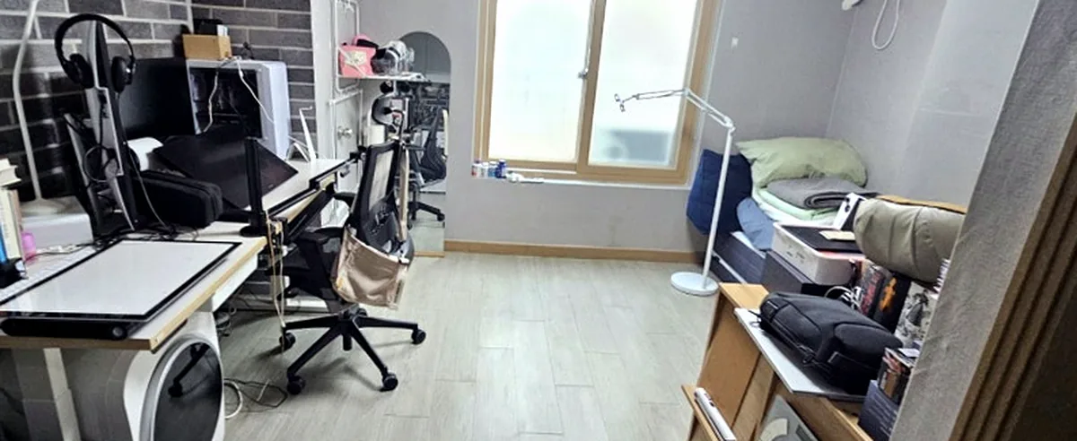 정리 후 원룸 — 밝은 회색 마루가 드러나고 책상과 매트리스가 정돈된 모습