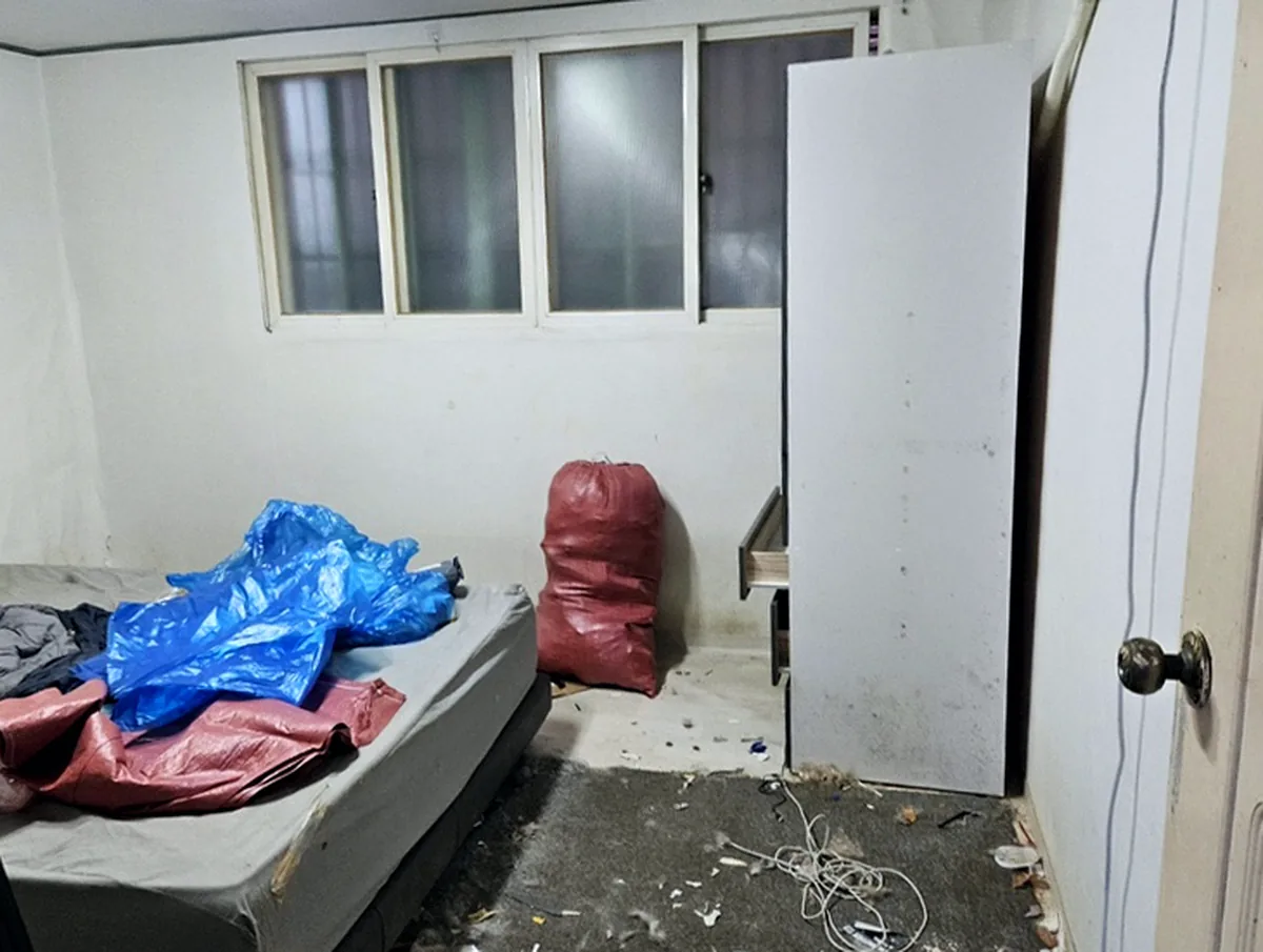 정리 전 침대방 — 매트리스 침대와 문짝 떨어진 옷장, 카펫 위 털과 전선, 남겨 둔 벽걸이 에어컨