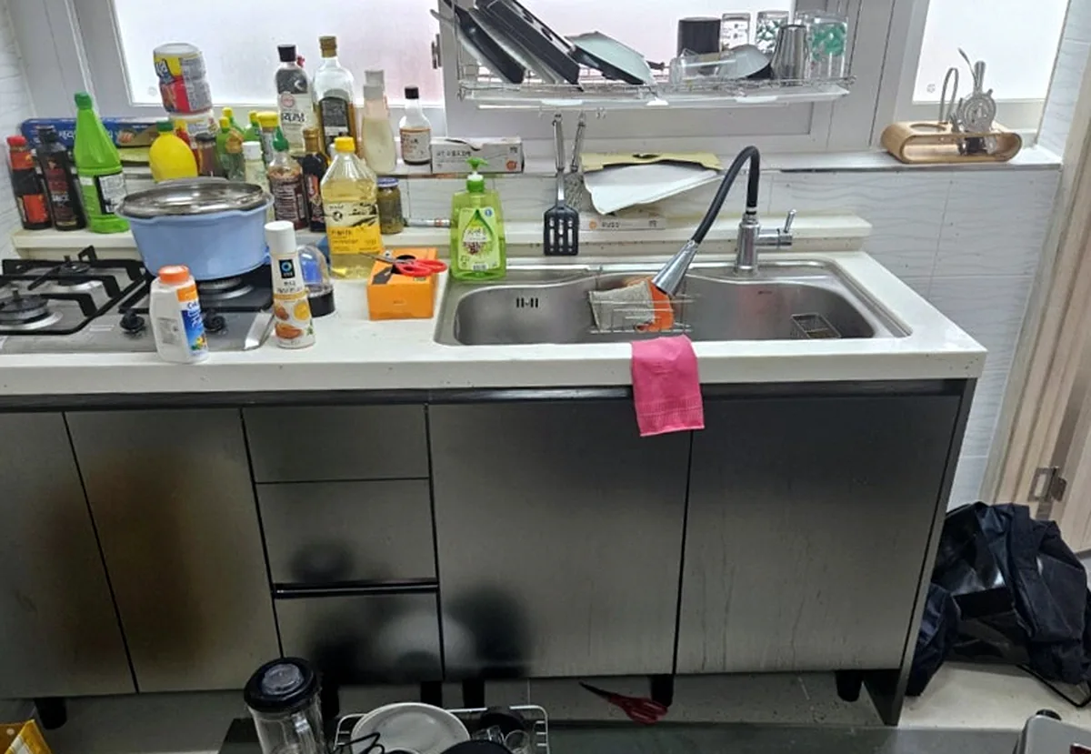 구로 오류동 빌라 주방 쓰레기집 청소 — 조리대를 채운 양념병·세제 통을 모두 치운 싱크대 작업 전