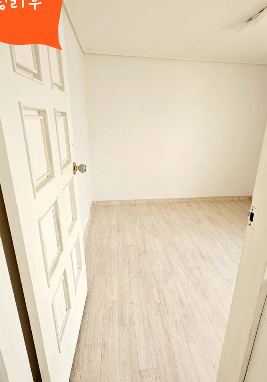 정리 후 주방 옆 방 — 흰 문 너머 짐이 모두 빠진 빈 방