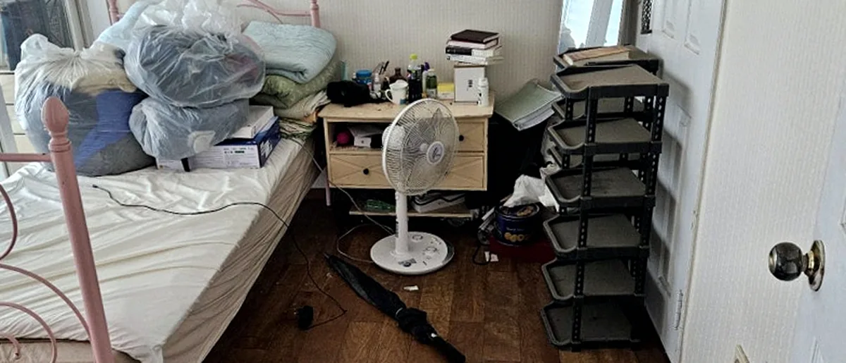 작업 중 침실 — 비닐로 싼 이불 뭉치와 신발장 선반이 남은 모습