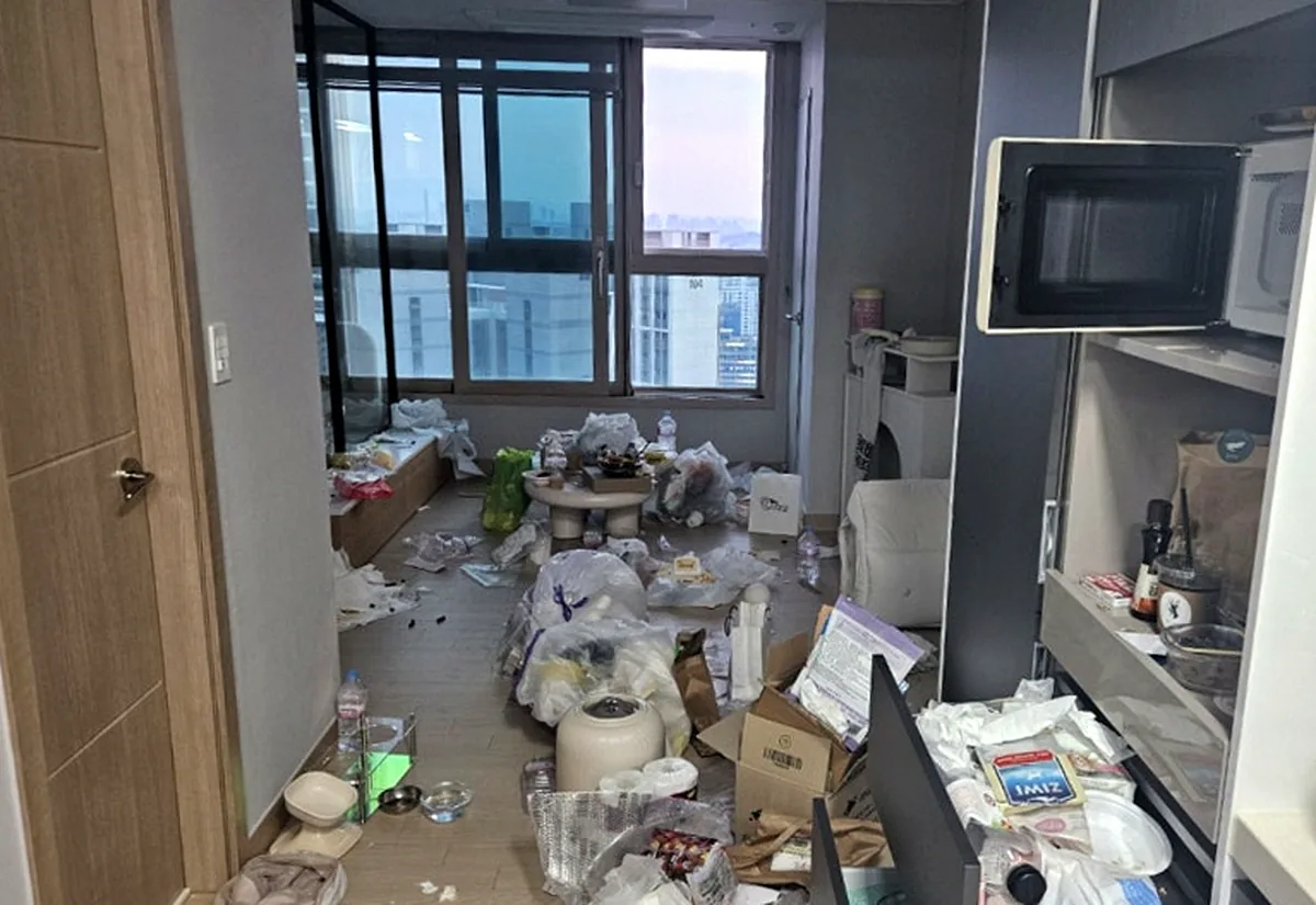 정리 전 거실 — 비닐봉지와 휴지, 택배 상자가 창 앞까지 덮인 바닥
